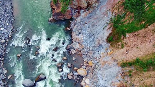 steep rocky cliff with a river flowing below.