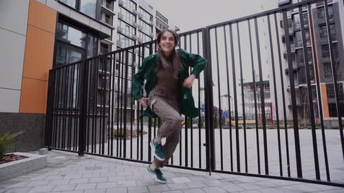 Woman Performing Energetic Dance in Urban Setting