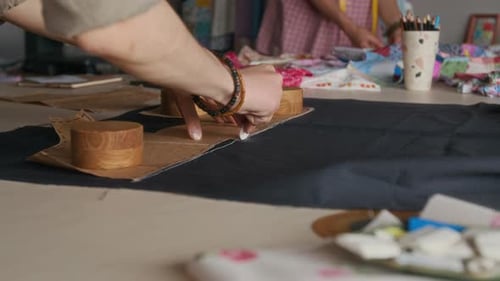 Hands of Seamstress Copying Pattern on Fabric with Chalk in Atelier