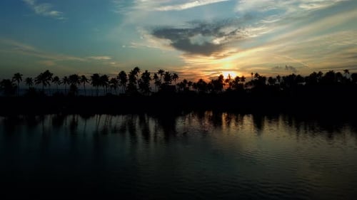 beautiful sunset clouds reflecting on a lake and silhouette Coconut trees , lake and blue twilight s