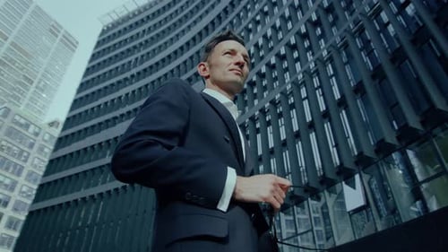 Man in Suit Standing by Modern Building