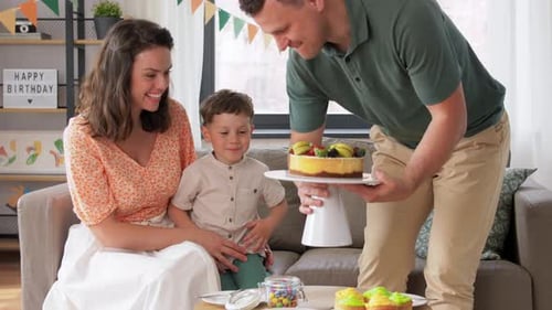 Family celebrating a birthday with cake indoors