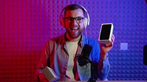 Man Unboxing Smartphone in Front of Microphone