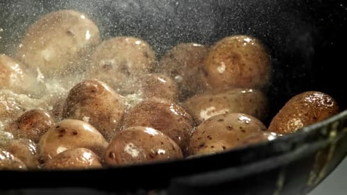 Potatoes Cooking in a Black Pan Close Up