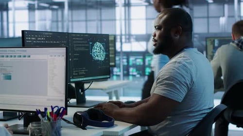 Man Coding at Computer in Bright Modern Office