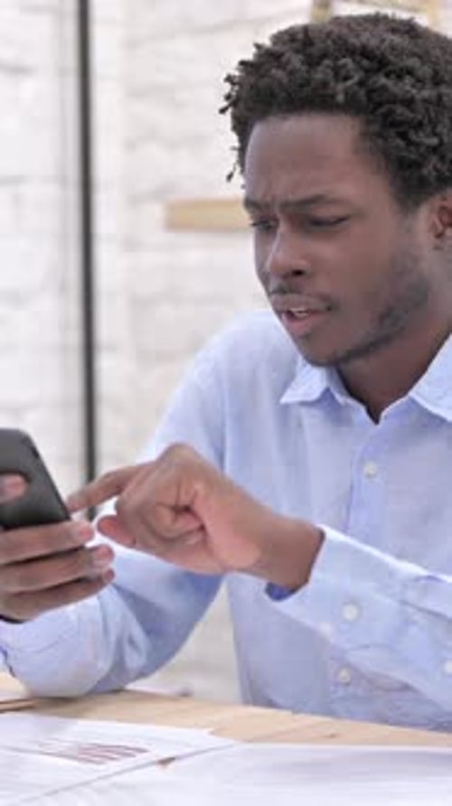 Excited Young Man Reacting to Good News on Phone