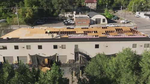 Roofers Renovating Large Building Roof with Damaged Plywood Replacement