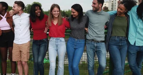 Multiracial Friends Having Fun Hugging Each Other On The Bridge In The City