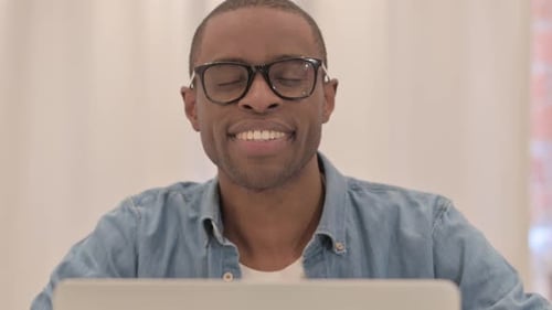 Smiling Young Adult with Glasses Working