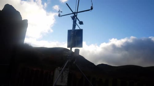 Mountain weather forecasting scientific station solar panel wind sensor mast under blue sky dolly le