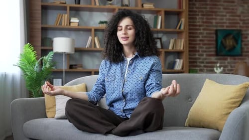 Woman Meditating on Sofa in Peaceful Home Interior
