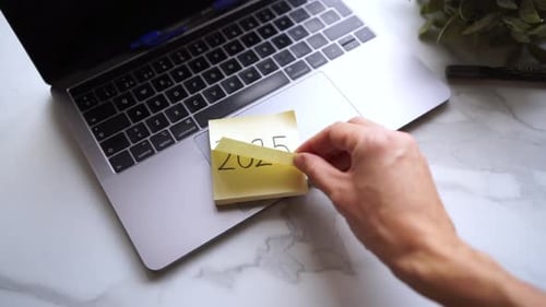 Hand Flipping Sticky Notes on Laptop: 2025 to 2026