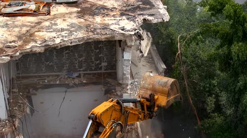 Excavator demolishing a residential building, Aerial view