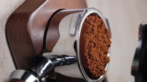 Tamping fresh coffee in portafilter for espresso