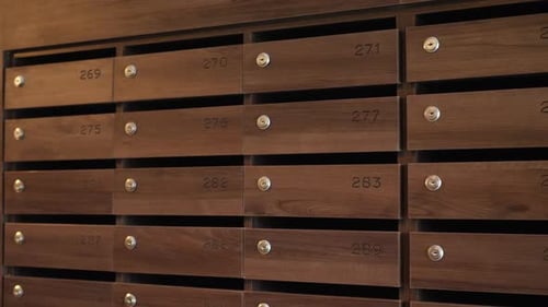 Close up of metal new mailboxes in the house entrance. Closed letter boxes indoors.