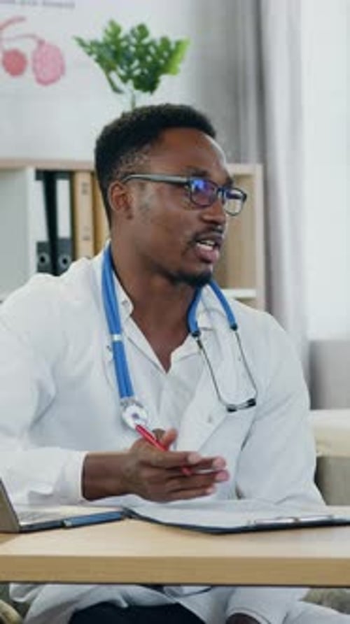 Focused Male Doctor Explaining Diagnosis at Desk