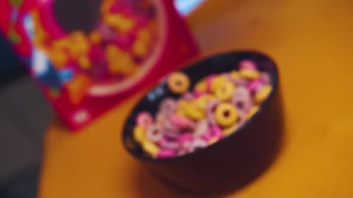 Colorful Cereals in a bowl with pour out milk in slowmotion.
