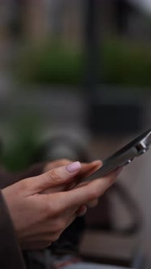 Woman's Hands Using a Smartphone in Urban Setting