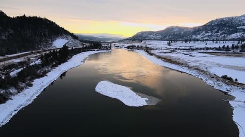 Une heure dorée au-dessus de la rivière Thompson à Kamloops, en Colombie-Britannique, avec ses sommets enneigés