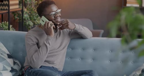 Young Adult Male Talking on Phone on Couch
