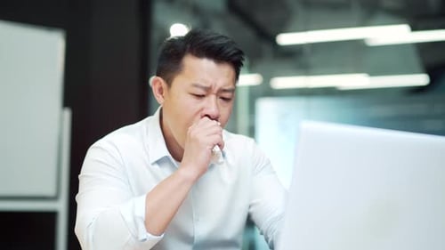 Sick asian businessman coughing in office workplace. Employee entrepreneur worker feeling unwell hav