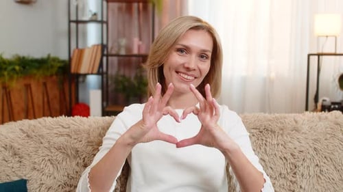 Woman Makes Heart Shape with Hands, Smiling