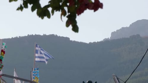 Un drapeau grec flotte dans le vent dans le port de Limenarias, à Thasos.