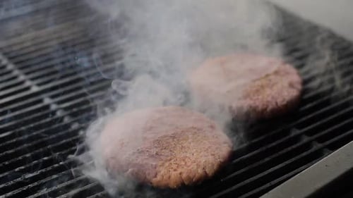 Chef Cooking Beef Patty for Burger on Hot Grill and Flip the Cutlet with a Spatula