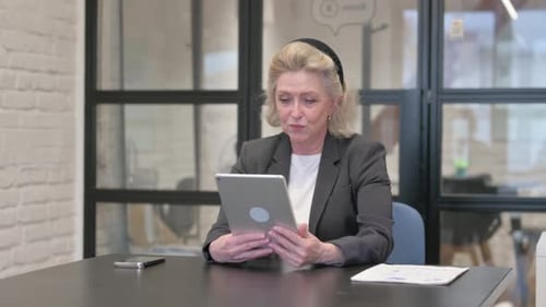 Senior Old Business Woman Doing Video Chat on Tablet in Office