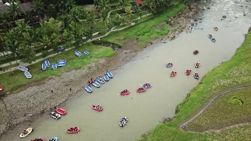 Aerial view of many rafting boats ply the river water