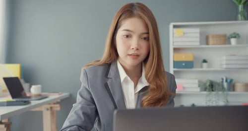 Asia businesswomen using laptop on table working and communicate sitting on office desk.
