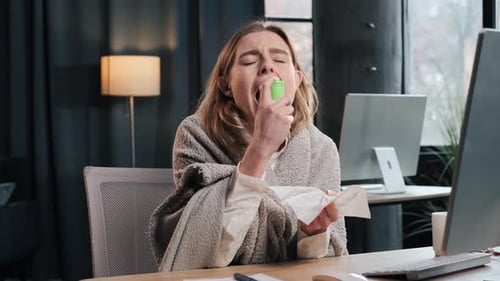 Femme d'affaires malade, directrice, enveloppée dans une couverture, faisant une inhalation orale