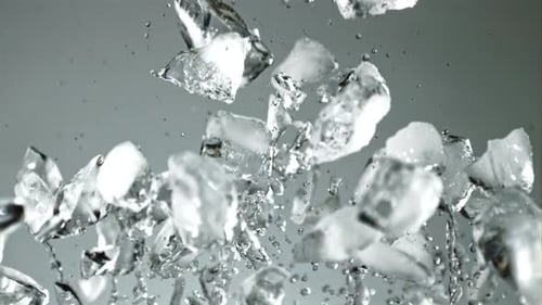Pieces of Ice with Splashes of Water Soar Up and Fall
