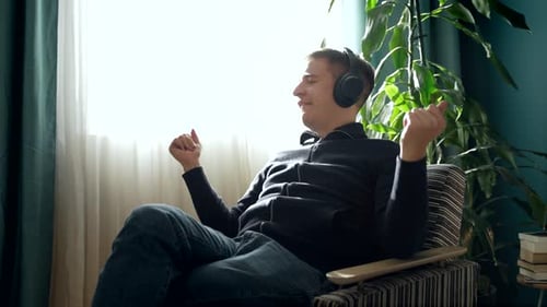 Man Relaxing at Home, Listening to Music