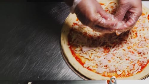 Preparing Pizza with Cheese and Ham in Kitchen