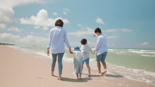 Asian father and mother play with child and walking along the beach