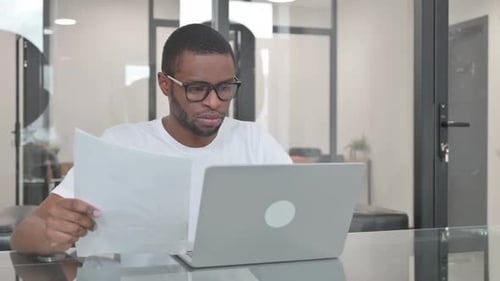 Concerned Adult Reviews Documents in Modern Office