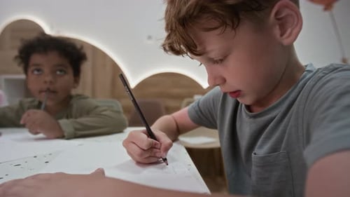 Petits garçons ayant des cours de dessin à la table