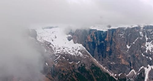 Aerial Shot of a Snowy Rocky Peak Wrapped in Clouds in the Dolomite Alps