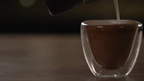 Cream Being Poured into a Cup of Coffee