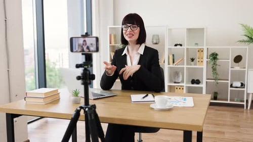 Woman in Suit Presenting Via Mobile Phone