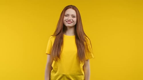Pretty Ginger Woman Smiling to Camera on Yellow Studio Background