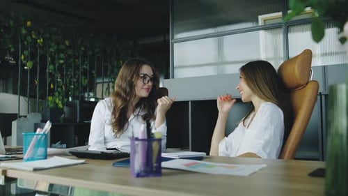 A Stern Boss Interrupts Two Women Chatting in the Office Expressing Disapproval As They Laugh