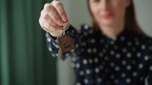 Closeup Purchase of Real Estate The Realtor Shows the Keys Closeup of the Hand and Documents The