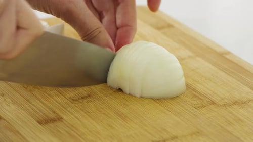 Slicing White Onion Into Thin Pieces for Cooking Preparation