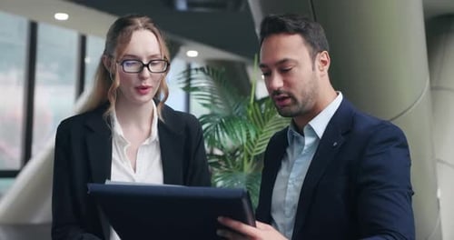 Business Professionals Reviewing Documents on Tablet in Office