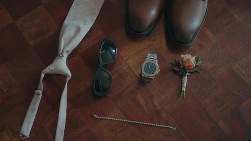 Groom accessories arranged on wooden floor before wedding