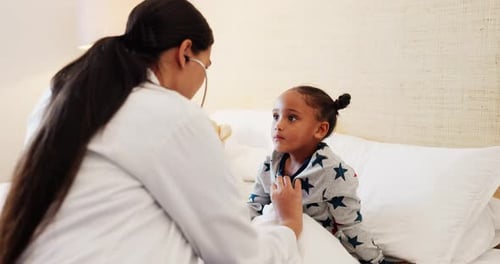 Doctor Examines Child on Bed at Home