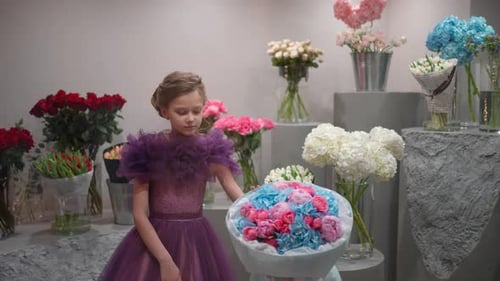 A Little Girl Chooses a Bouquet in a Flower Shop The Concept of Buying Flowers