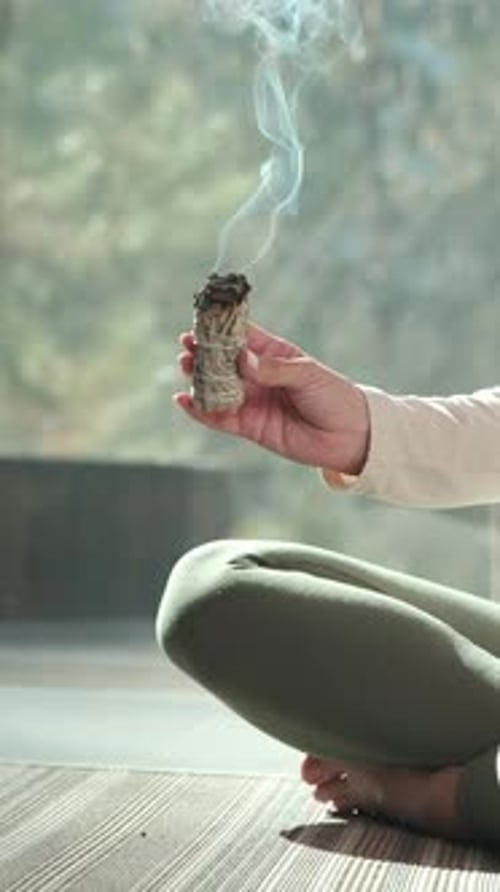 Woman Burning Sage While Sitting Cross-Legged